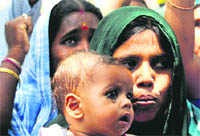 Rani, widow of road wing employee Mahesh, with her child during a protest outside the MC office in Sector 17, Chandigarh, on Tuesday. 