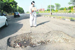 Victim Labh Singh shows the pothole on the road separating Sectors 66 and 67 in Mohali.