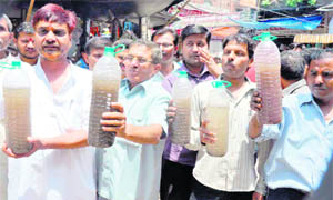 Residents of the Vishnu Ghat-Moti Bazar area carry bottles containing contaminated water being supplied at their houses