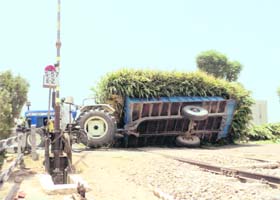 An overloaded tractor-trailer overturns on the railway line at Shahkot on Tuesday
