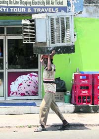 A man carries an air cooler as mercury rises in Jammu