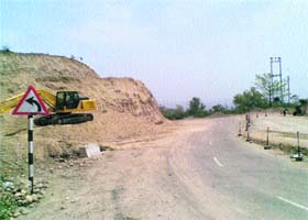 An earth mover at work, near Jagti, to connect six villages with the NH-1A