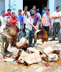 Booze lovers collect nips and pints from damaged liquor boxes in front of a vend, which was attacked by human rights activists, in Bathinda on Tuesday