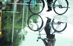 The image of a cyclist seen on a road after showers lashed Chandigarh on Wednesday