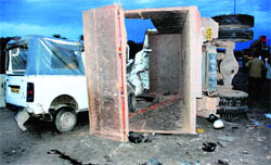 A truck that overturned after hitting a median and landed on a cab on the flyover near Bir Ghaggar village