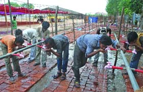 Labourers have water at the venue in New Delhi on Wednesday
