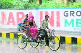 A RIDE IN THE RAIN: A rickshaw-puller goes about his job as usual in Karnal on Wednesday