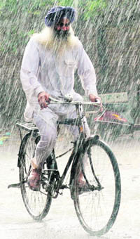 A farmer makes his way through rain in Amritsar 