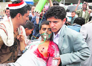 A wounded Yemeni dissident tribesman is carried to a makeshift clinic outside Sanaa University during clashes with government forces on Wednesday