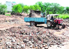Caught in the act A JCB machine fills a tractor-trailer belonging to a building contractor with ‘malba’ at a dumping site in Sector 50, Chandigarh, on Thursday