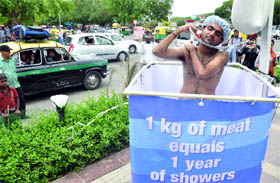 An activist from the People for The Ethical Treatment of Animals (PETA) takes a public shower in Connaught Place to highlight the high usage of water involved in a meat-based diet, in New Delhi on Thursday.