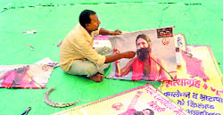 A worker readies Ramdevs posters at Delhis Ramlila Ground on Thursday.
