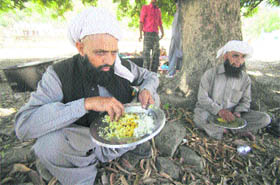Bakerwals have meal after casting their vote at Surinsar during the 13th phase of the panchayat elections 