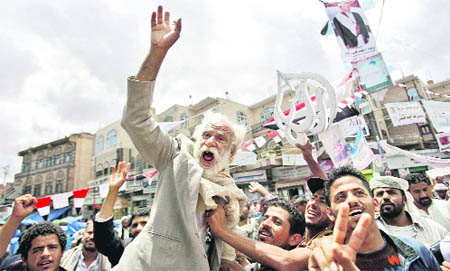 An anti-government protester, lifted by other demonstrators, reacts during a protest demanding