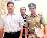 A Quadri, accused of defrauding his employers company, being led out of the district courts by the police in Chandigarh on Friday.