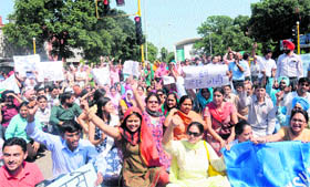 Sarv Shiksha Abhiyaan teachers block traffic in support of their demands at the Sector 22 light point in Chandigarh on Friday.