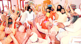 Religious heads raise their hands in support of Swami Ramdevs movement against corruption in Haridwar.