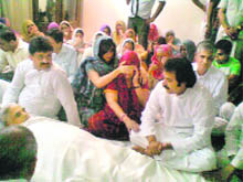 Former Chief Minister Bhajan Lal's sons, Kuldeep Bishnoi and Chander Mohan, sit beside the body of their father in Hisar on Friday. 