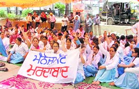 Nurses of Mohan Dai Oswal Cancer Treatment & Research Foundation raise slogans against the management in Ludhiana on Friday