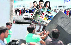 Youths pull down hoardings and posters of Salman Khan starrer 'Ready' in protest against his comments against Swami Ramdevs satyagraha in Haridwar on Saturday
