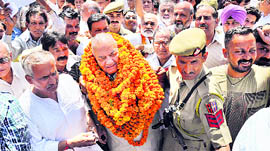 Chaman Lal Gupta, expelled BJP leader, comes out of the Jammu airport with his supporters on Saturday.