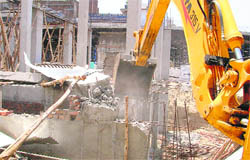  A building under construction near Deepak Cinema in Ludhiana being razed on Saturday. 