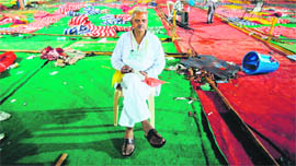 A supporter of yoga guru Ramdev sits under an empty marquee after his supporters were forcefully evicted by the police from the Ramlila Maidan where he was observing a fast against corruption, in New Delhi on Sunday.  Reuters 