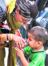 SWEET MOMENT: A child drinks sweetened water at a chhabeel in Jammu on Sunday