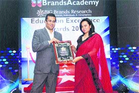 Indian novelist Chetan Bhagat presents an award to a representative of an institute in Gurgaon