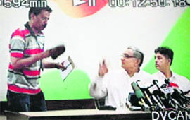 A TV grab shows a person posing as a journalist trying to attack Congress general secretary Janardhan Dwivedi with a shoe at the AICC headquarters on Monday.