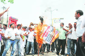 Congress workers burn an effigy of Ramdev in Dehradun on Tuesday. 
