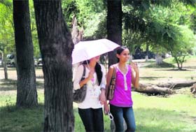 These girls use an umbrella to protect themselves from the sun on the Jammu University campus