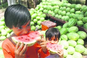 These little girls have a juicy treat at a stall selling watermelons in Jammu