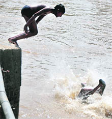 With mercury rising in the city, children dive in canal water to beat the heat