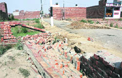 Demolished walls of a house in an illegal colony that was razed during a drive by municipal corporation officials on the Tibba Road in Ludhiana on Tuesday