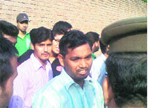 Hari Lal (the victim), an employee of PUs secrecy branch, talks to security personnel outside the Aruna Ranjit Chandra Hall on Wednesday