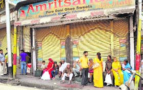 Tourists outside closed shops at Raghunath Market in Jammu on Wednesday