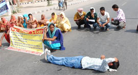 Members of the AIE Teachers Front blocking road in support of their demands in Bathinda on Thursday.