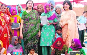 Vaneeta Kumaria (centre) and Ashima Sabharwal (right) distribute stationary items among villagers at Meerpur near Sirsa