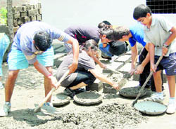 Students of Doon School,Scindia Kanya Vidyalaya, Gwalior and Sanskar Valley School, Bhopal engaged in preparing bricks for low cost house of a poor woman Gulabo Devi at Fathegram village near Vikasnagar in Dehradun district