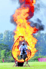 An Army daredevil rider passes through a ring of fire at Indian Military Academy, Dehradun, on Friday