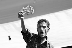 A file photo shows a protester holding a piece of bread with the word "Leave!" baked on it during an anti-government rally in Sanaa, Yemen