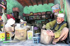 Far from the hectic life in cities, an old shokeeper busy with daily chores at his workplace in Shangus village of Anantnag district.