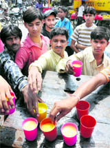 Sweet Gesture: People partake of sweetened water at a chhabeel organised by shopkeepers at Committee Chowk in Karnal on Saturday.