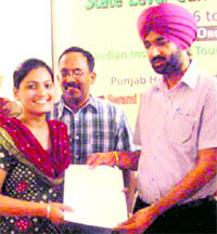 Deputy Commissioner KS Pannu issues a state-level tourist guide licence to a girl in Amritsar on Friday. Trained by the Indian Institute of Travel and Tourism Management, 27 boys and girls will operate as guides across the state