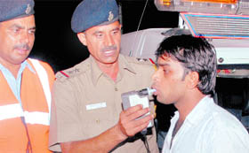 Traffic policemen use an alcohol-testing device on a driver at the Sector 51-52 dividing road in Chandigarh on Sunday night.