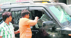 Angry villagers damage a car during a protest against the killing of two youths in Faridabad