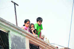 Children look towards the house where murder took place in Ludhiana. 