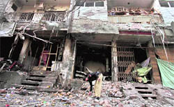 A Pakistani police officer searches for evidence at the site of an explosion in Peshawar on Sunday