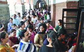 Parents and students queue up on the last day for the submission of forms at St. Stephens College in New Delhi on Monday